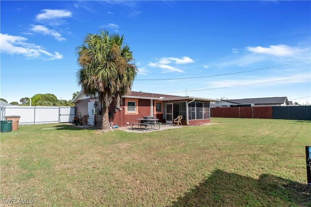 view of yard featuring a sunroom, a fenced backyard, and a patio area