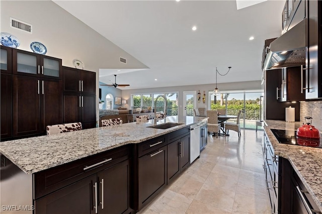 kitchen with black electric cooktop, visible vents, under cabinet range hood, and a sink