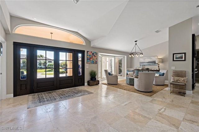 entrance foyer featuring a notable chandelier, baseboards, and vaulted ceiling