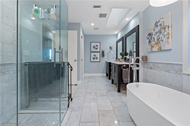 full bathroom with vanity, visible vents, a freestanding tub, a shower stall, and marble finish floor