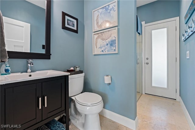 bathroom with baseboards, toilet, and vanity