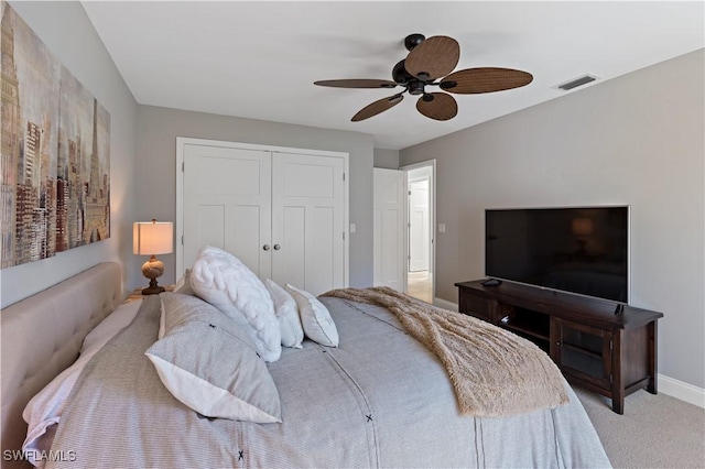 bedroom featuring visible vents, baseboards, ceiling fan, a closet, and light colored carpet