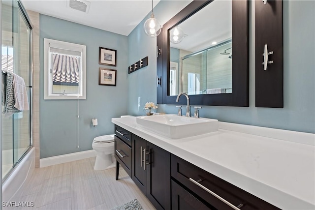 full bathroom featuring vanity, baseboards, visible vents, toilet, and combined bath / shower with glass door