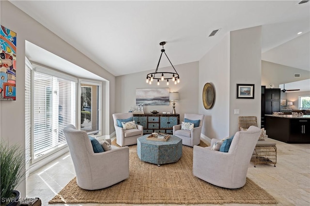 living area with visible vents, a healthy amount of sunlight, baseboards, and lofted ceiling