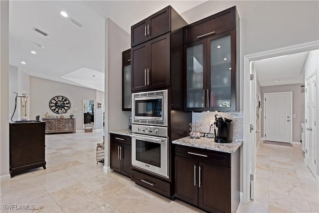 kitchen with light stone counters, visible vents, backsplash, and appliances with stainless steel finishes