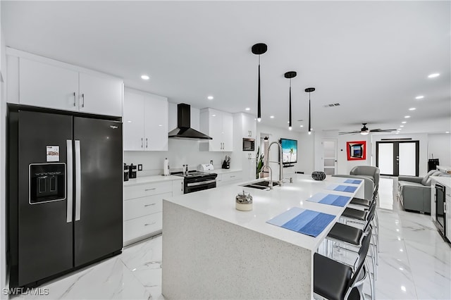 kitchen with fridge with ice dispenser, a sink, electric stove, wall chimney range hood, and marble finish floor