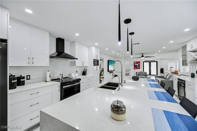 kitchen featuring white cabinetry, stainless steel electric stove, modern cabinets, and wall chimney range hood