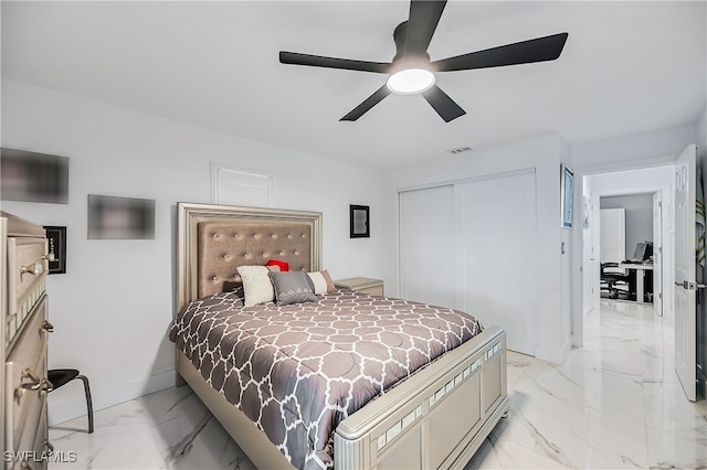 bedroom with visible vents, marble finish floor, a ceiling fan, a closet, and baseboards