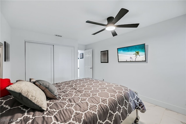 bedroom with visible vents, marble finish floor, a ceiling fan, a closet, and baseboards