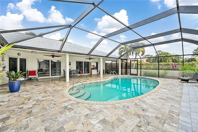 pool featuring glass enclosure, ceiling fan, and a patio area