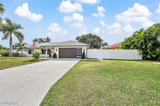 view of front of house with fence, stucco siding, concrete driveway, a front lawn, and a garage