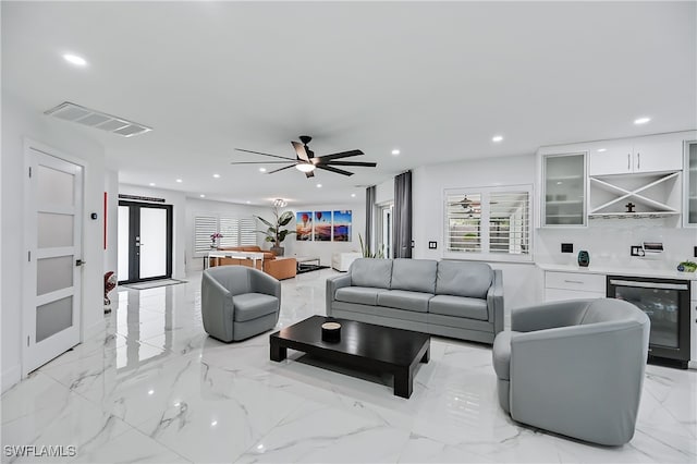 living area with recessed lighting, beverage cooler, visible vents, and marble finish floor