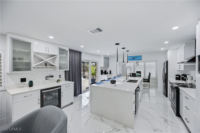 kitchen with visible vents, modern cabinets, black appliances, beverage cooler, and a sink