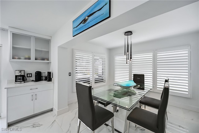 dining space featuring marble finish floor and baseboards