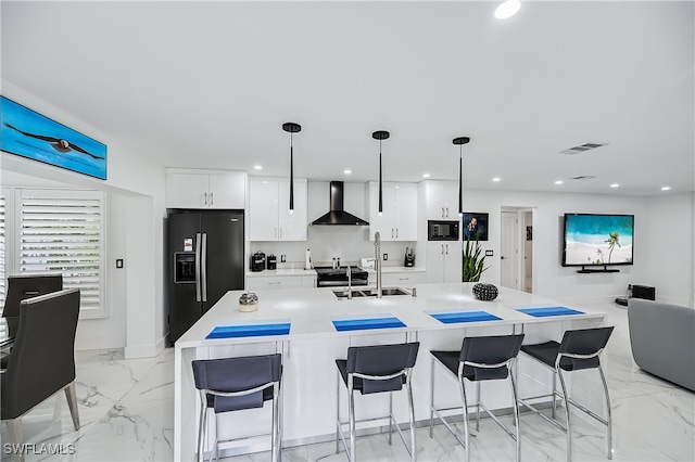 kitchen with white cabinets, black appliances, marble finish floor, and wall chimney range hood