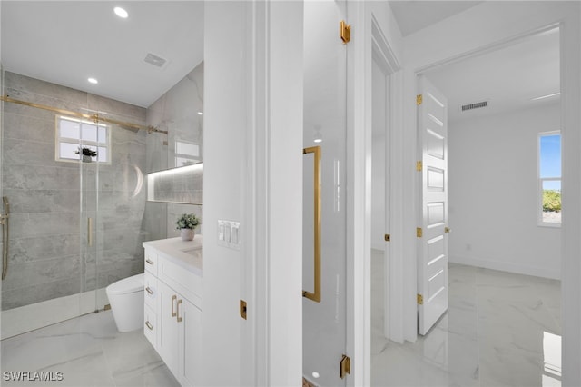 full bathroom featuring vanity, marble finish floor, a shower stall, and a healthy amount of sunlight