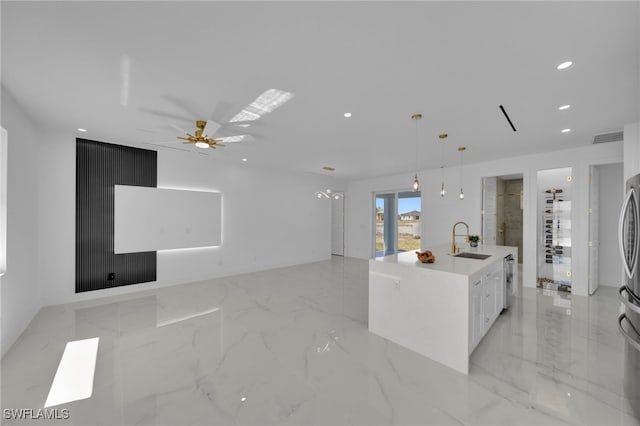 kitchen with a center island with sink, recessed lighting, a sink, white cabinets, and marble finish floor