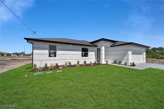 view of front of property with an attached garage, concrete driveway, a front yard, and a shingled roof