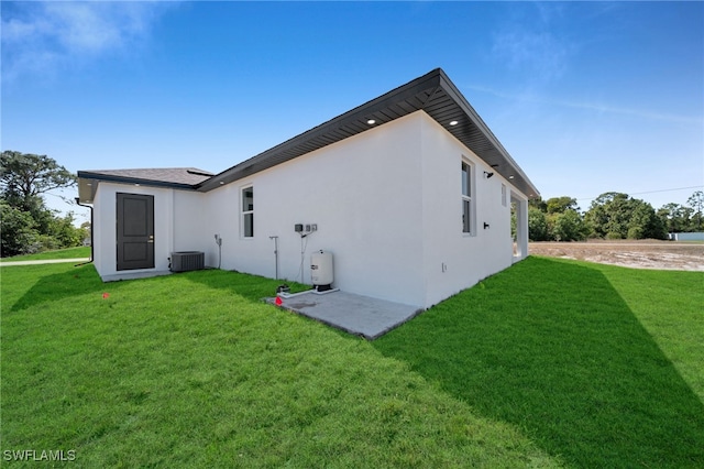 back of house featuring central AC unit, a lawn, and stucco siding