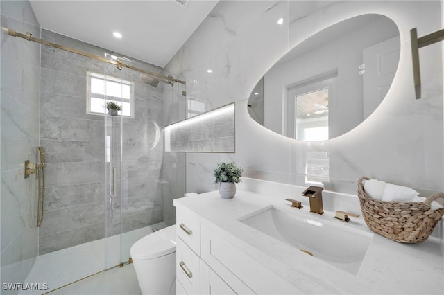 bathroom featuring vanity, tile walls, toilet, and a stall shower