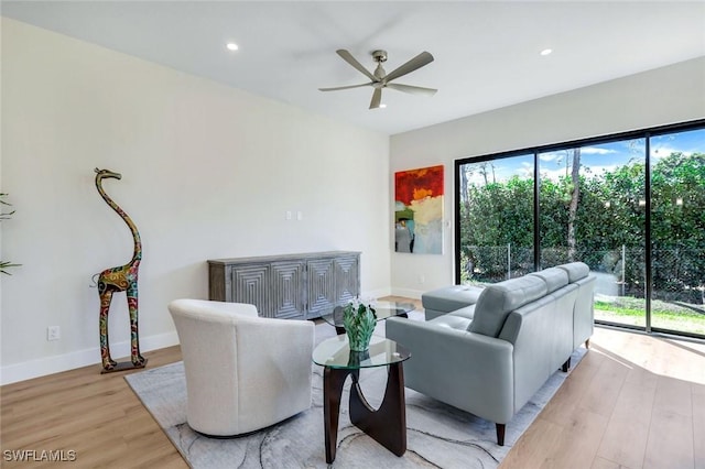 living room featuring a wealth of natural light, recessed lighting, baseboards, and light wood finished floors