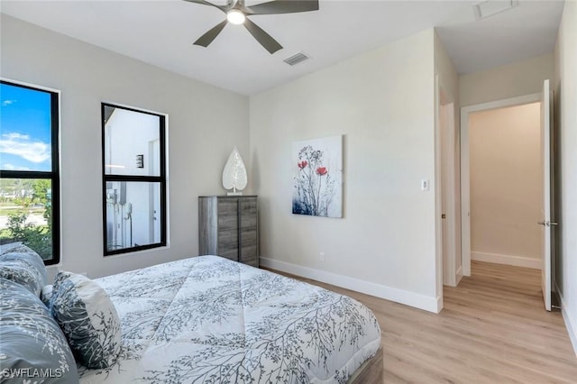 bedroom featuring visible vents, light wood-type flooring, and baseboards