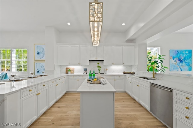 kitchen with a peninsula, a sink, light wood-style floors, stainless steel dishwasher, and tasteful backsplash