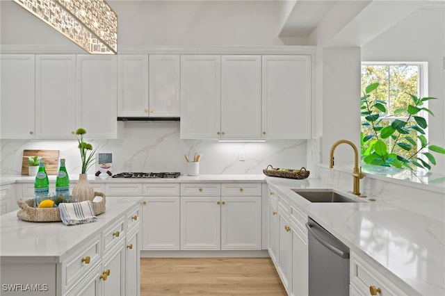 kitchen with a sink, stainless steel appliances, white cabinets, and decorative backsplash