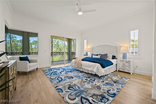 bedroom with access to exterior, multiple windows, wood finished floors, and ornamental molding