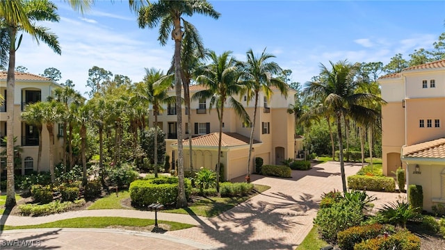 surrounding community with decorative driveway and a garage