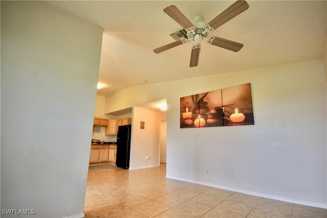 empty room with light tile patterned floors, baseboards, ceiling fan, and vaulted ceiling