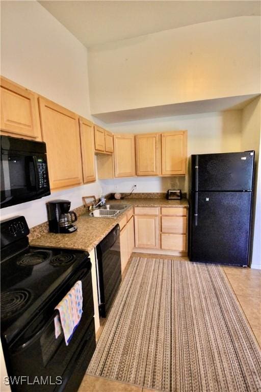 kitchen with black appliances, light brown cabinets, light countertops, and a sink