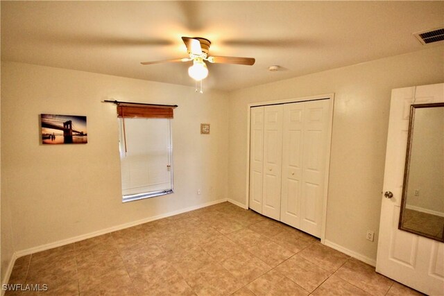 unfurnished bedroom featuring a ceiling fan, baseboards, visible vents, and a closet