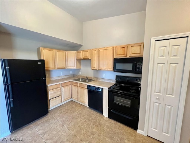 kitchen with black appliances, light brown cabinetry, and light countertops