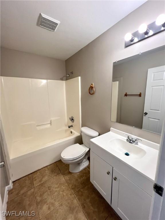 bathroom with vanity, visible vents, tile patterned flooring, shower / tub combination, and toilet