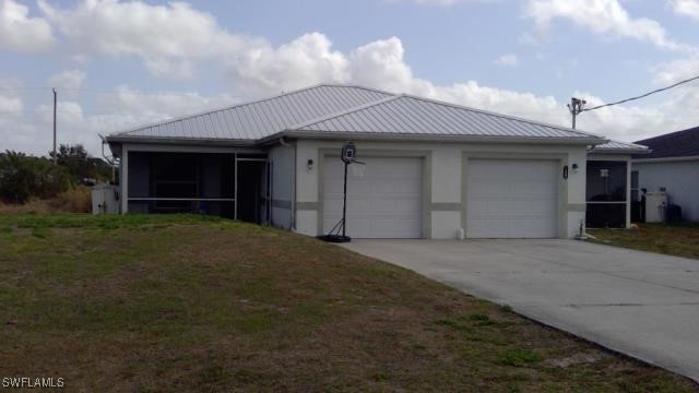 view of front of house featuring stucco siding, driveway, a sunroom, a front yard, and an attached garage