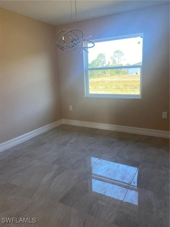 2910 28th St W, Lehigh Acres, FL 33971 - spare room featuring a chandelier and baseboards