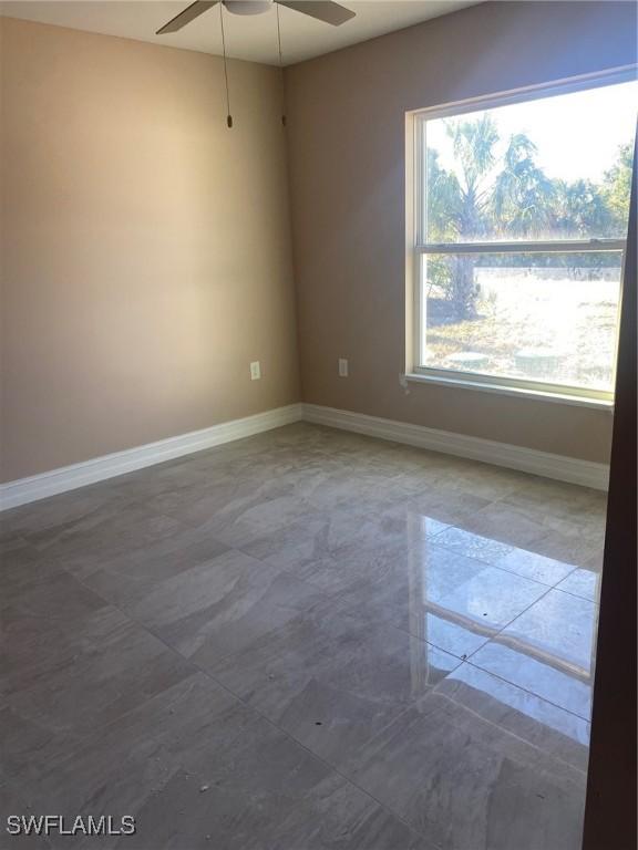 2910 28th St W, Lehigh Acres, FL 33971 - spare room featuring baseboards and ceiling fan