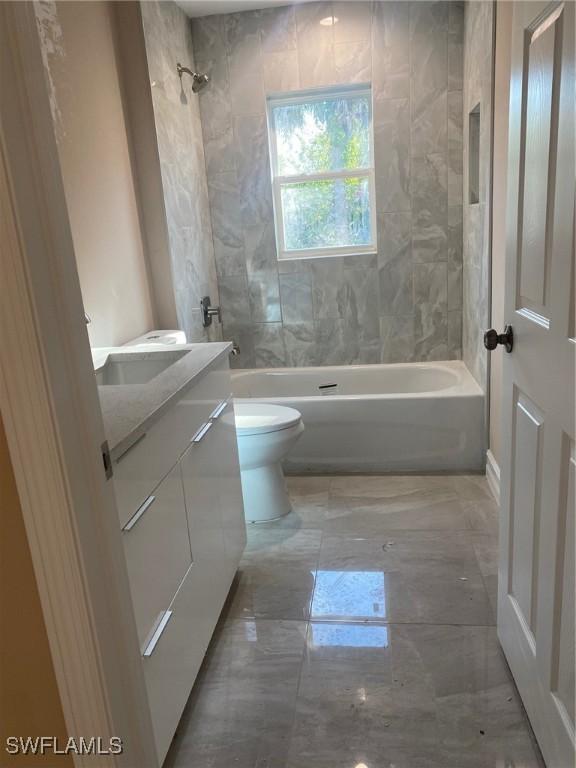 2910 28th St W, Lehigh Acres, FL 33971 - full bathroom with shower / washtub combination, vanity, marble finish floors, and toilet