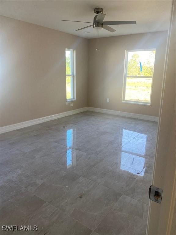 2910 28th St W, Lehigh Acres, FL 33971 - spare room with baseboards and a ceiling fan
