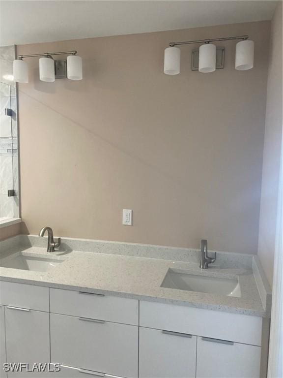 bathroom featuring a sink, a shower, and double vanity