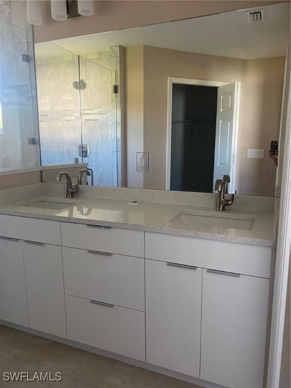 2910 28th St W, Lehigh Acres, FL 33971 - full bathroom with a stall shower and double vanity
