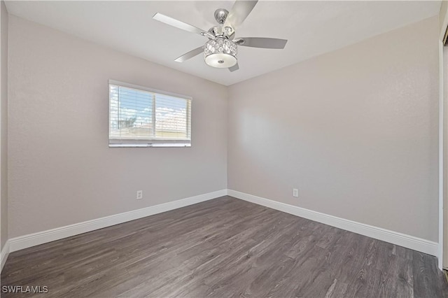 unfurnished room featuring dark wood-type flooring, a ceiling fan, and baseboards