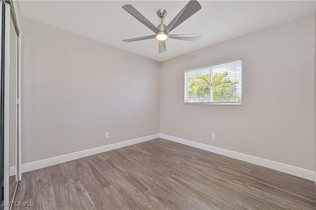 unfurnished room with a ceiling fan, baseboards, and wood finished floors