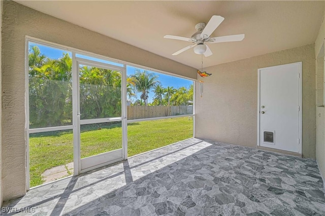 unfurnished sunroom with ceiling fan