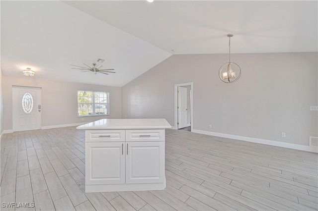 kitchen featuring ceiling fan with notable chandelier, open floor plan, white cabinetry, light countertops, and wood tiled floor