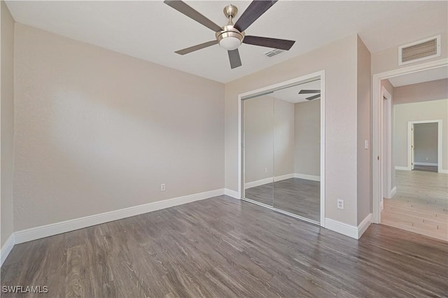 unfurnished bedroom featuring visible vents, baseboards, and wood finished floors