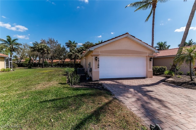 garage with central air condition unit and decorative driveway