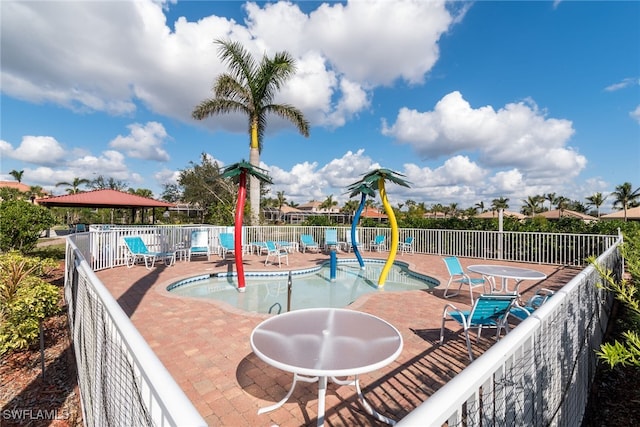 view of playground with a patio, a community pool, and fence