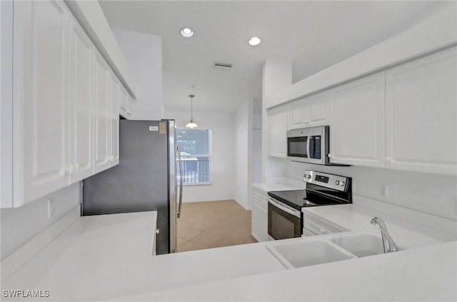 kitchen featuring visible vents, a sink, appliances with stainless steel finishes, white cabinets, and light countertops